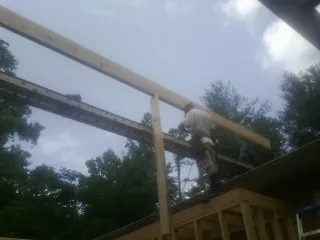 Carpenter setting a ridge beam over a new addition frame — Ice Dam Removal by Roofing Brothers in Beaver Falls