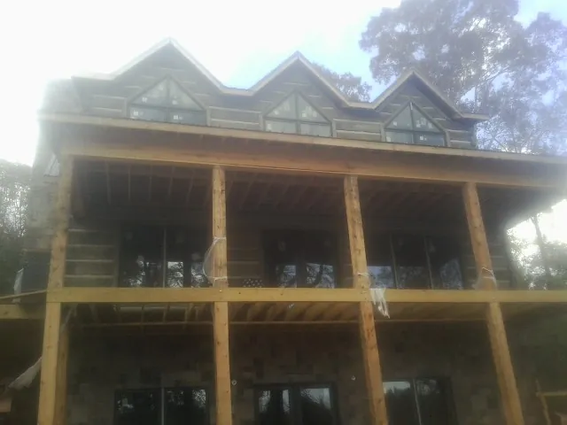 Dormers and porch framing on a large log home under construction — Roof Coating work by our crew in Beaver Falls