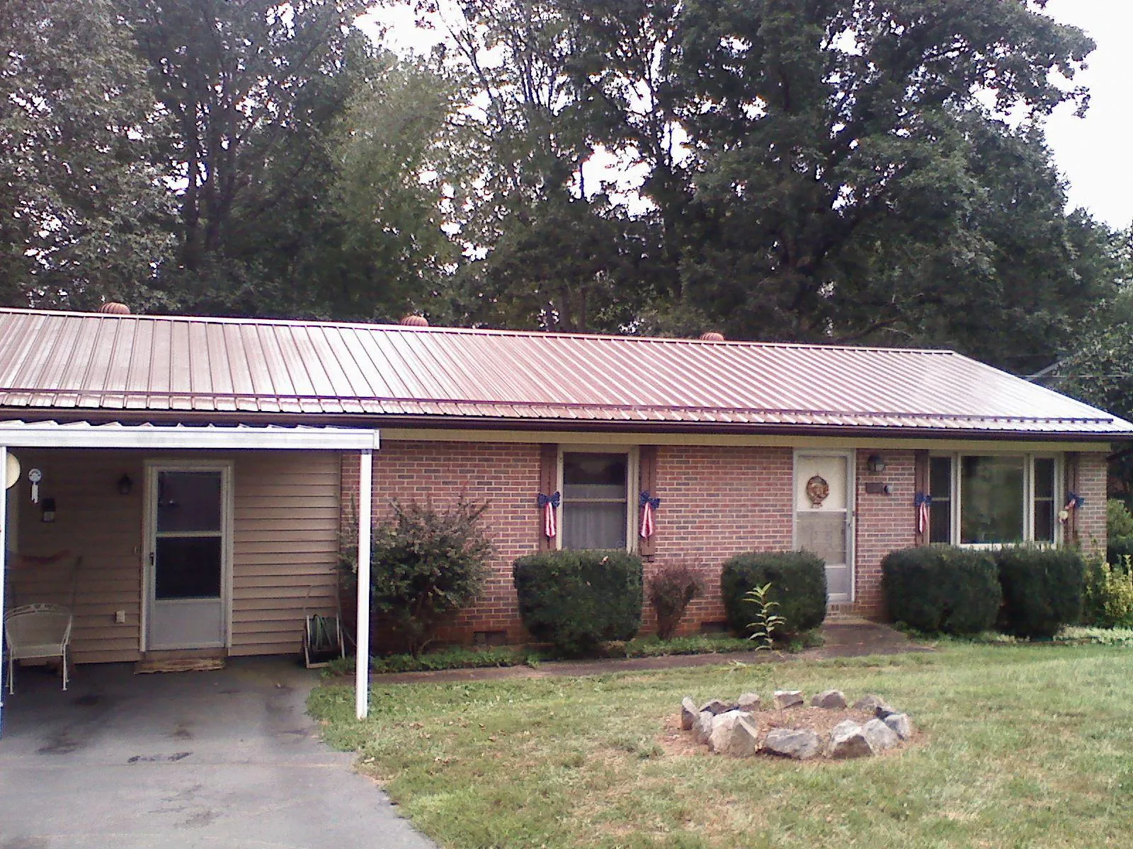 Bronze metal roof and carport on a brick ranch home — Roof Repair work by our crew in Beaver Falls