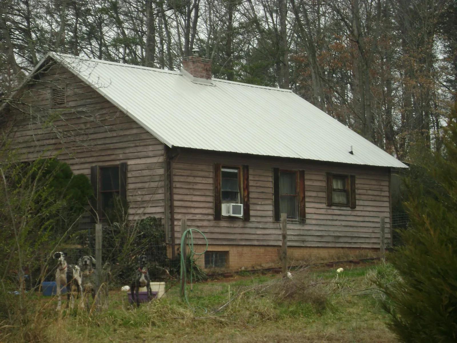 White metal roof on an old wood sided farmhouse, from a Metal Roof Installation job in Beaver Falls
